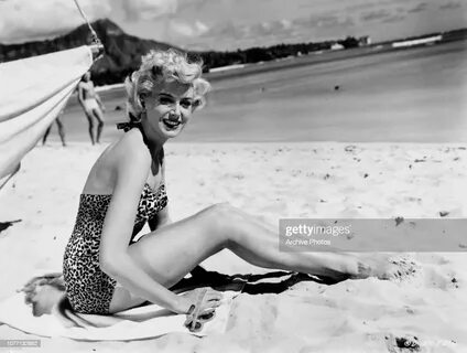 Scottish actress Deborah Kerr poses in a leopard print swimsuit on the beac...