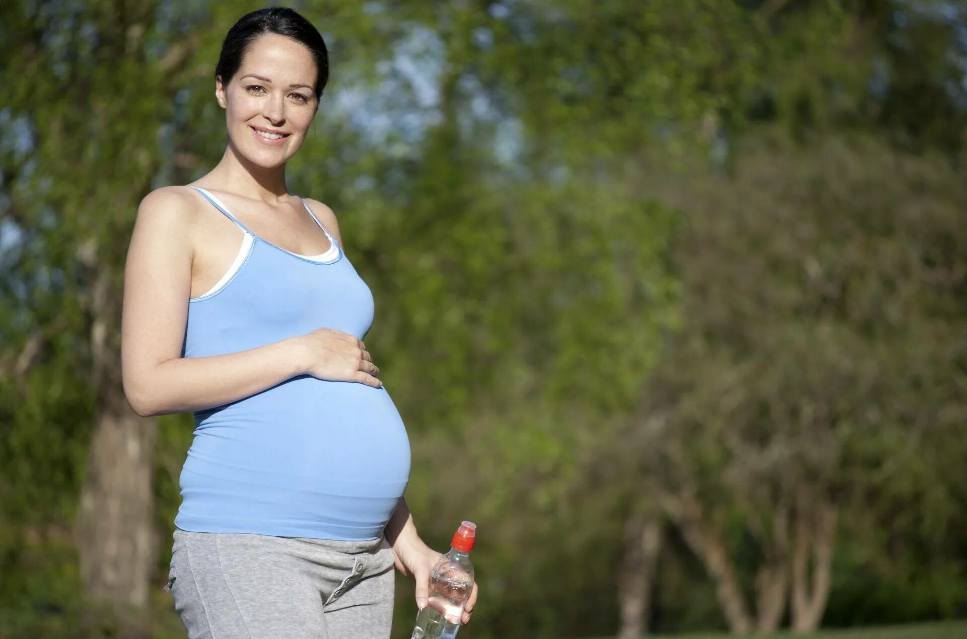 Woman is pregnant. Прогулки беременных. Прогулка беременной женщины. Беременные на прогулке.