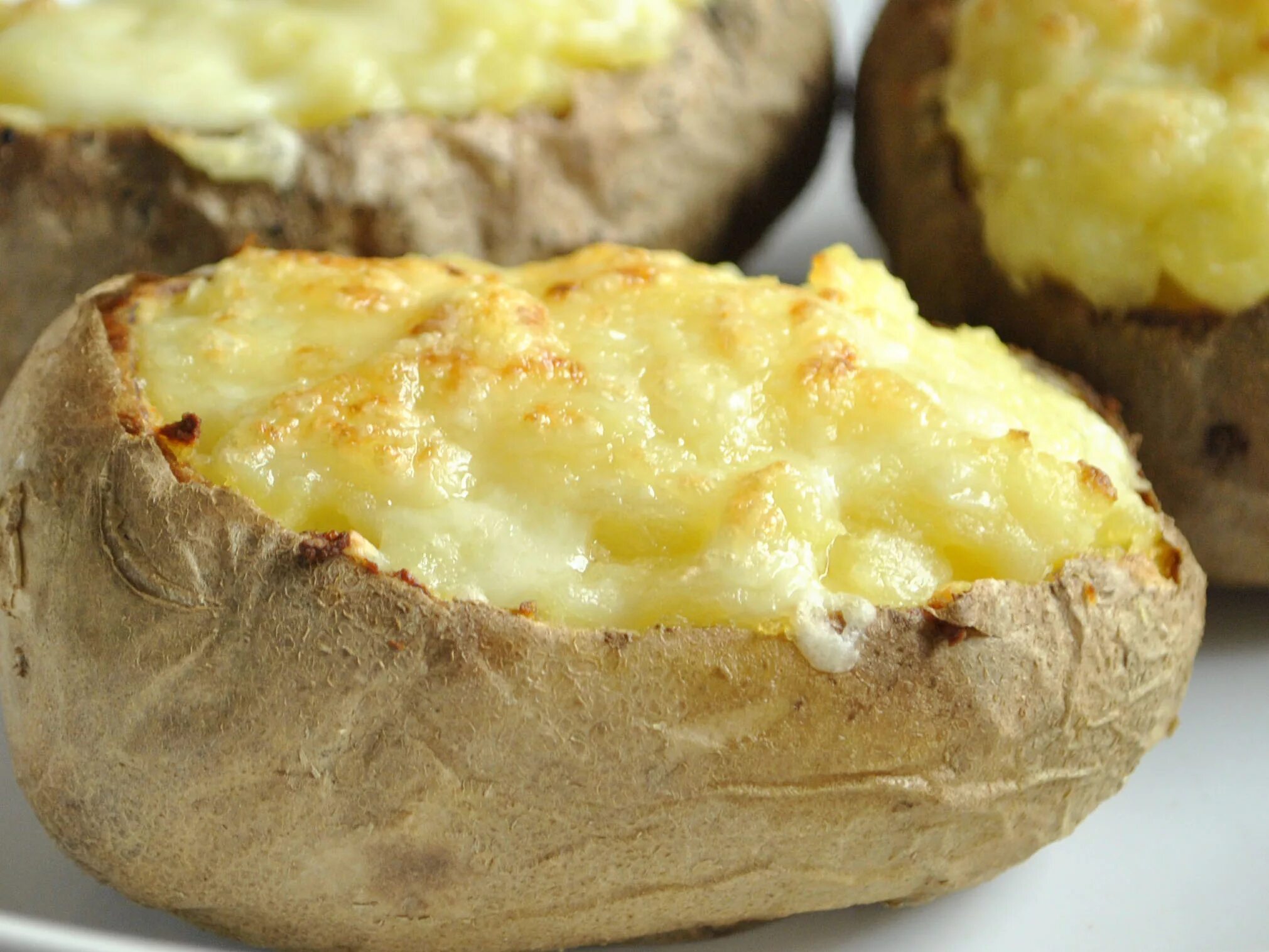 Картофель приготовленный в духовке с сыром. Картошка с сыром. Картошка с сыром в духовке. Картошка запеченная в духовке с сыром. Печеный картофель с сыром.