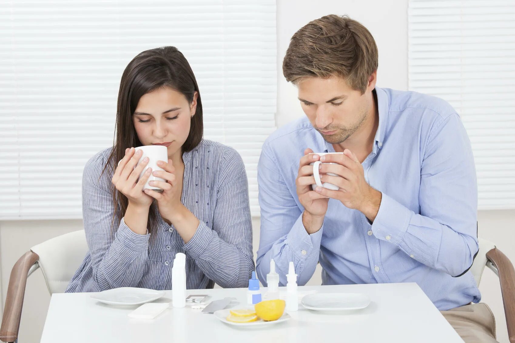 Couple drinking Detox. За столом она запивает таблетку водой, а её муж и отец пьют чай. Непереносимость кофе