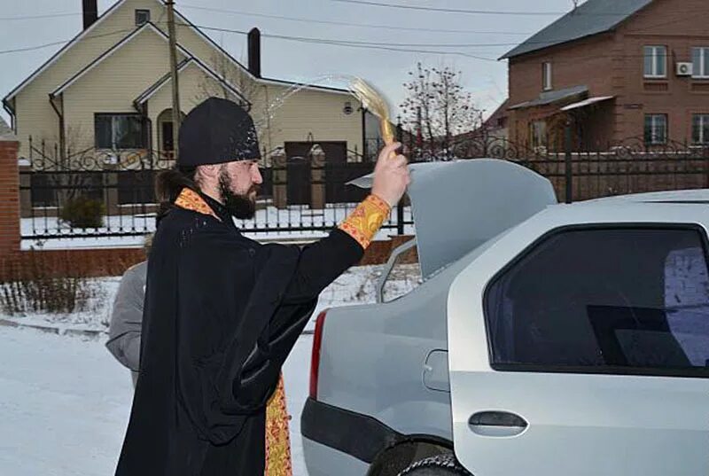 священник освящает автомобиль. освятить машину. освятить машину. купание депутатов. освящение автомобиля.