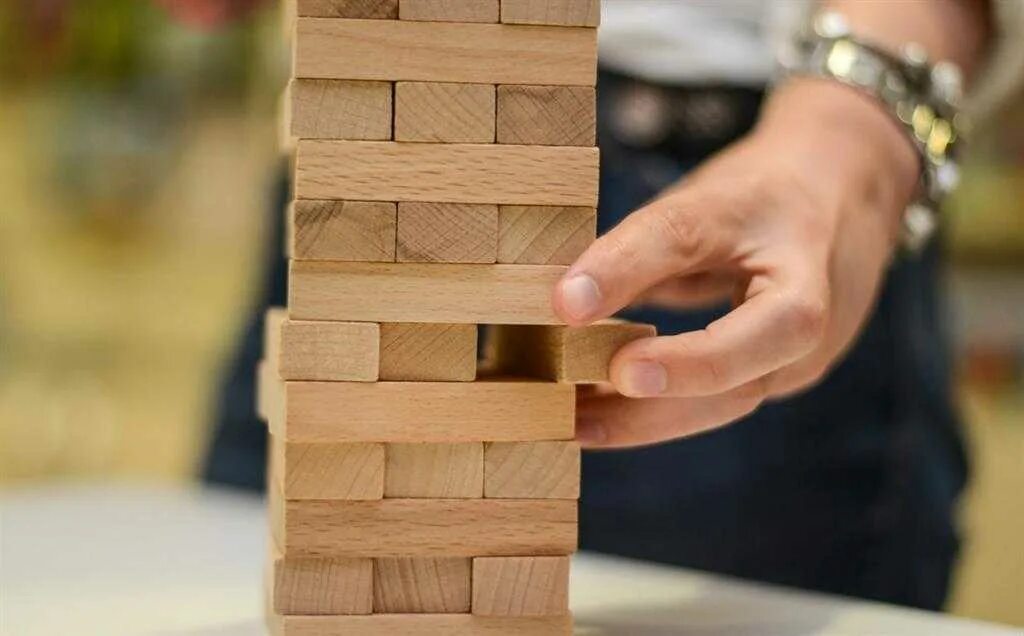 Игра вытаскивать палочки из башни. Jenga игра. игра дженга (jenga). падающая башня дженга. дженга 1970.