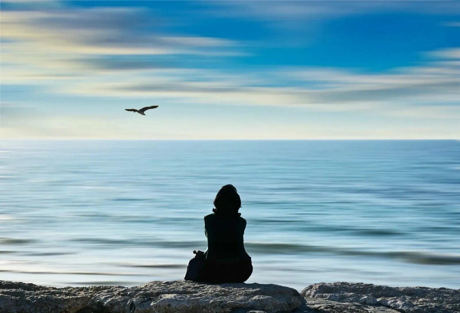 Живой вдали. Одиночество на берегу моря. Одинокая девушка у моря. Силуэт на фоне моря. Это одиночество.