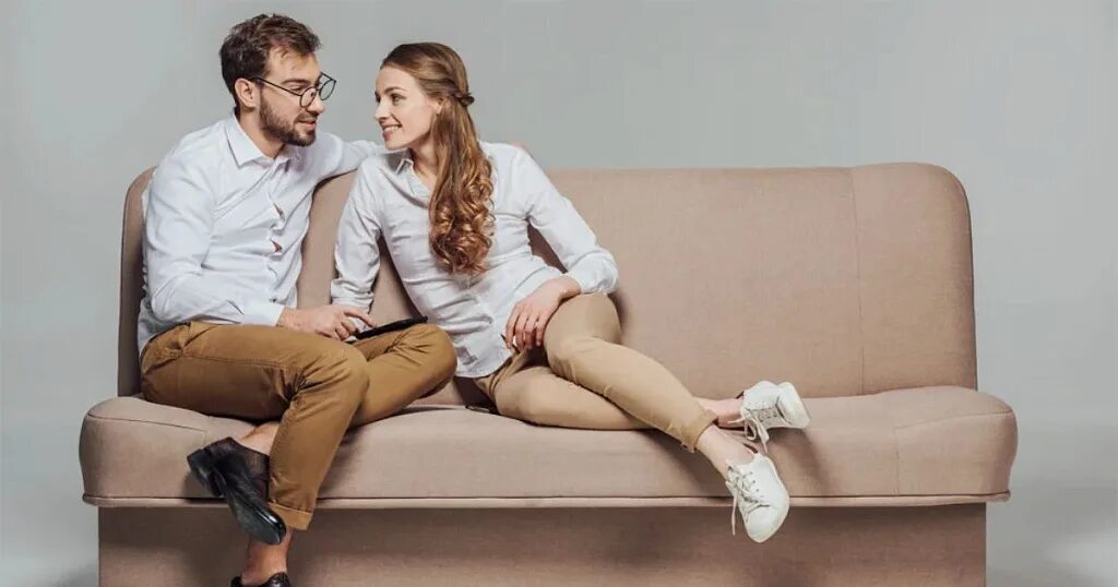 Пара сидит на диване. Любовь втроем. Две девчонки и парень сидят. Трое в постели. Парень с девушкой сидят на дива.