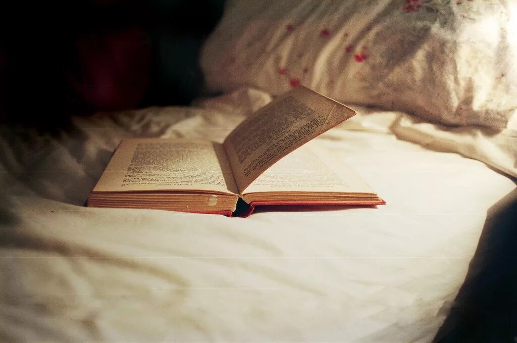 На столе лежит книга которая отражается. Книжка на постели. Книга в постели. Чтение книги в кровати. Книга на кровати.