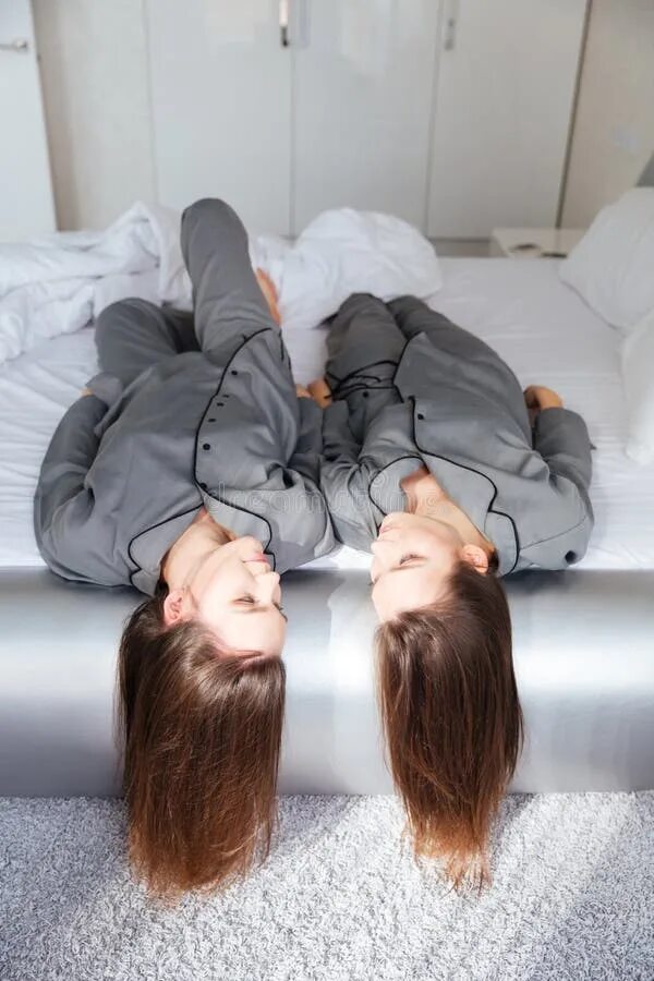 Сестры в пижамах кровать. Близняшки на кровати. Две сестры в пижаме. Фотосессия сестренок на кровати.