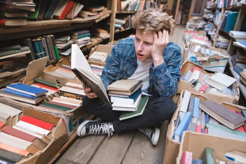 Библиотека студента. Завалило книгами. Сидит за книгами. Человек над книжками. Человек заваленный книгами.