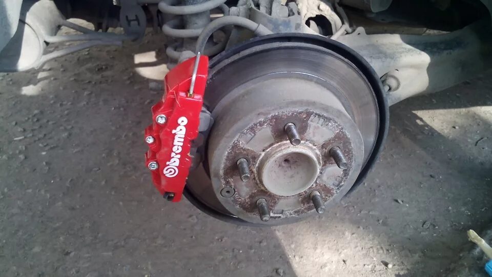 Усиленные суппорта. Накладки на суппорта BREMBO Mitsubishi Lancer 10. Накладки на суппорта Мицубиси Лансер 10. Лансер 10 суппорта 1.8 колесо. Накладки Брембо на суппорта Лансер 10.