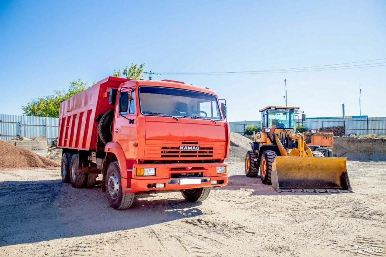 Автопарк самосвалов. Фронтальный погрузчик грузит КАМАЗ. КАМАЗ С песком. КАМАЗ самосвал с песком. Погрузка самосвала.