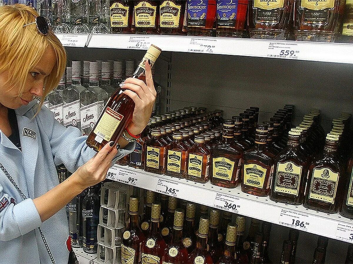 витрина с алкоголем. водка в красном белом. спиртное в кб. алкогольные напитки в красно белом. кб ассортимент алкоголя.