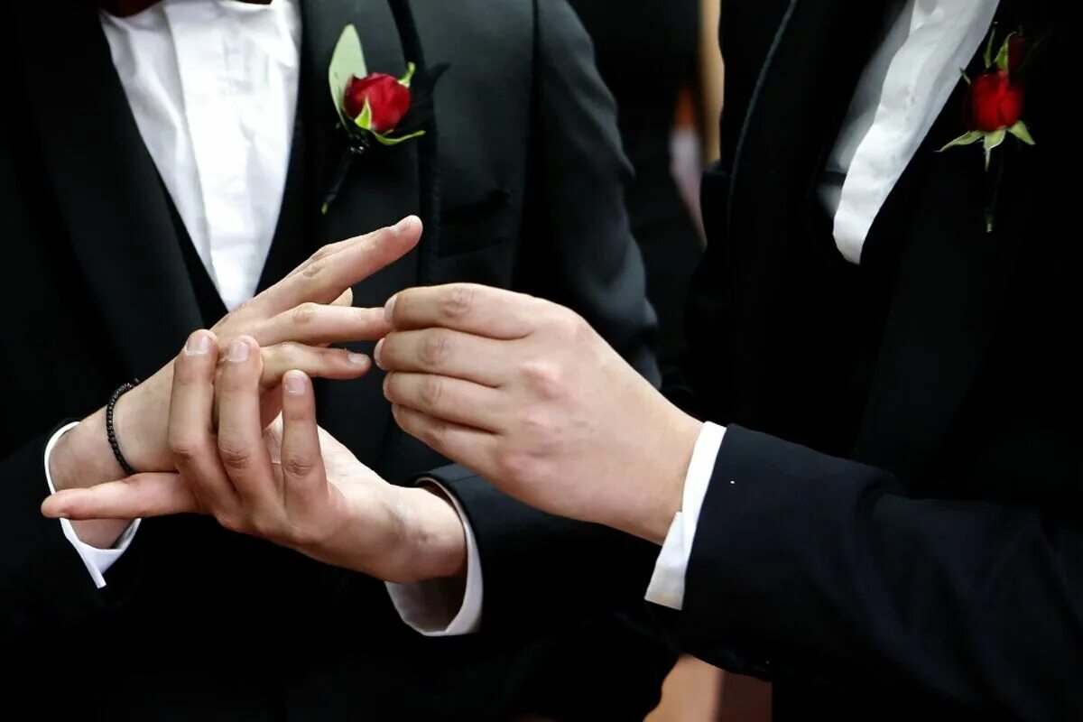 Кольцо брак на какой руке. Обручальные кольца на руках. Мужские кольца на руке. Мужские обручальные кольца на руке. Свадебная фотосессия кольца.