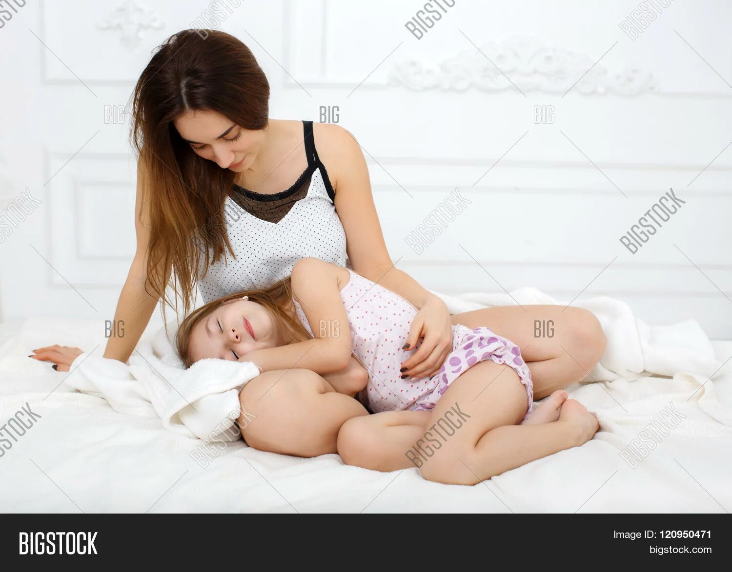 Мама и дочь лежат на кровати. Дочка лежит на маме. Молодые мамы в постели. Молодая мама с дочкой в кровати.