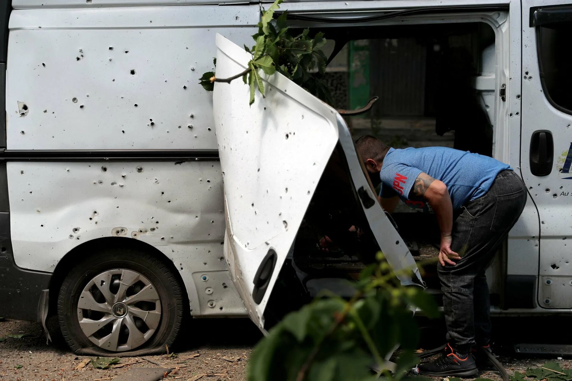 Мужчина 8 июня. Reuters местный житель осматривает поврежденный фургон. Reuters местный житель осматривает фургон 8 июня Харьков. Reuters Ukraine фургон.