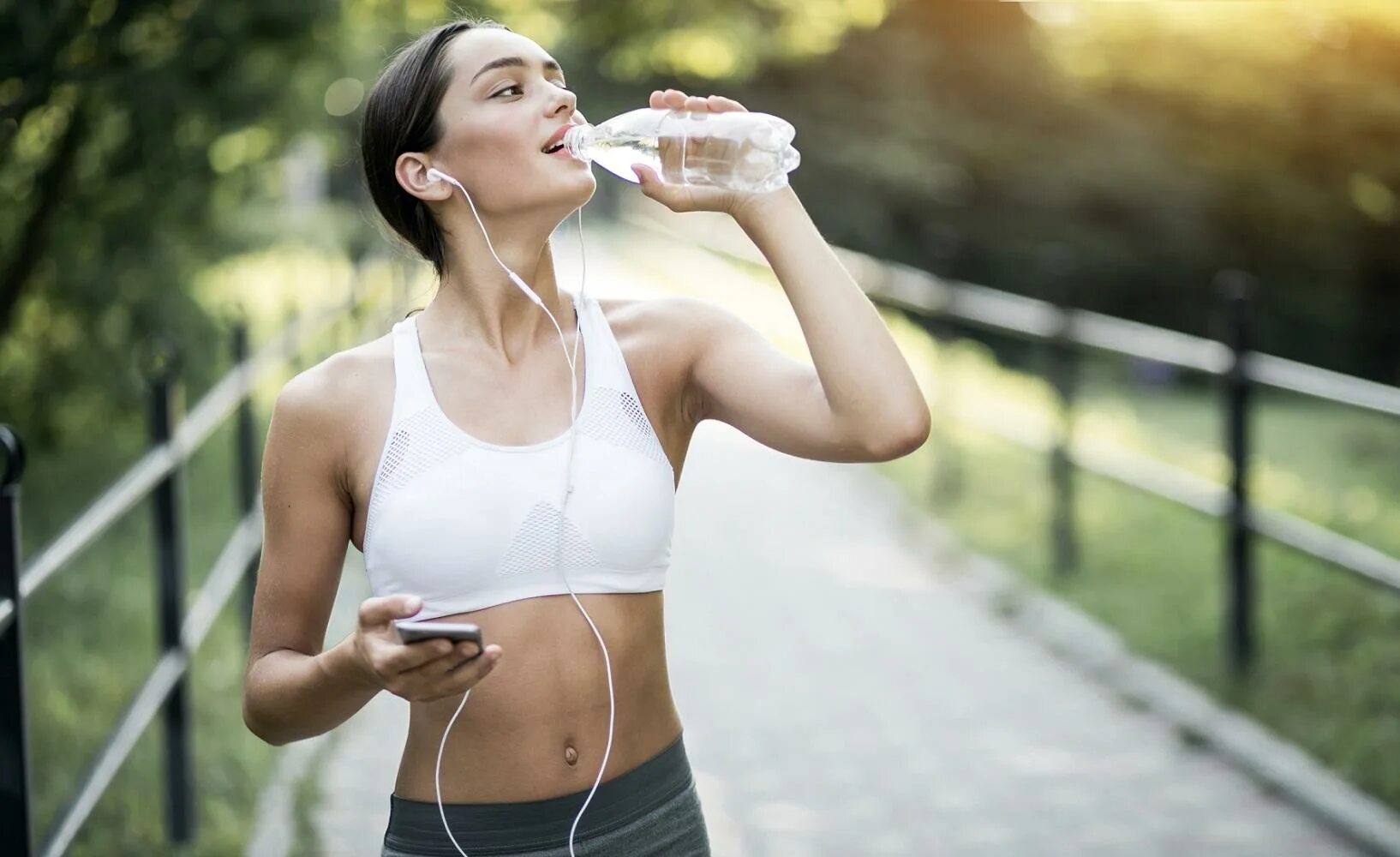 Водный образ жизни. Спортивная девушка пьет воду. Девушка после пробежки. Спортсмен пьет воду. Спортивная девушка с бутылкой воды.