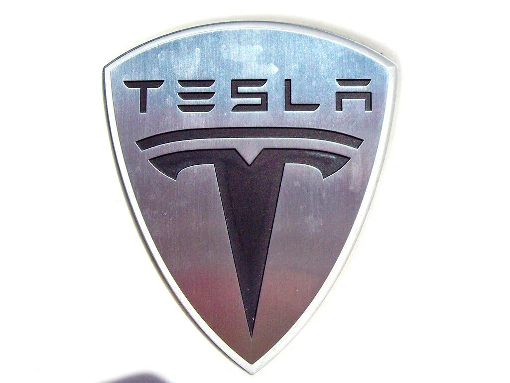 Знак теслы на машине. Тесла значок. Значок Tesla на машине. Марки машин значки Тесла. Значок марки автомобиля Тесла.