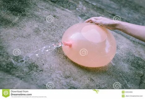 фото около Воздушный шар воды желтого цвета владением руки Gilr на внешнем ...