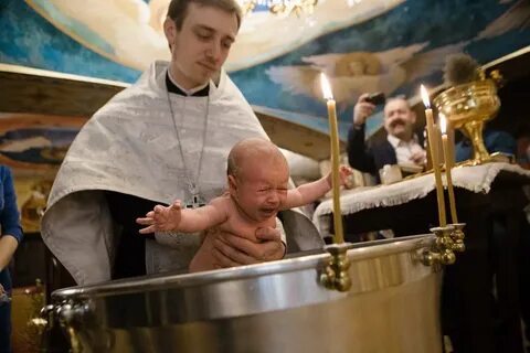 Священник крестит