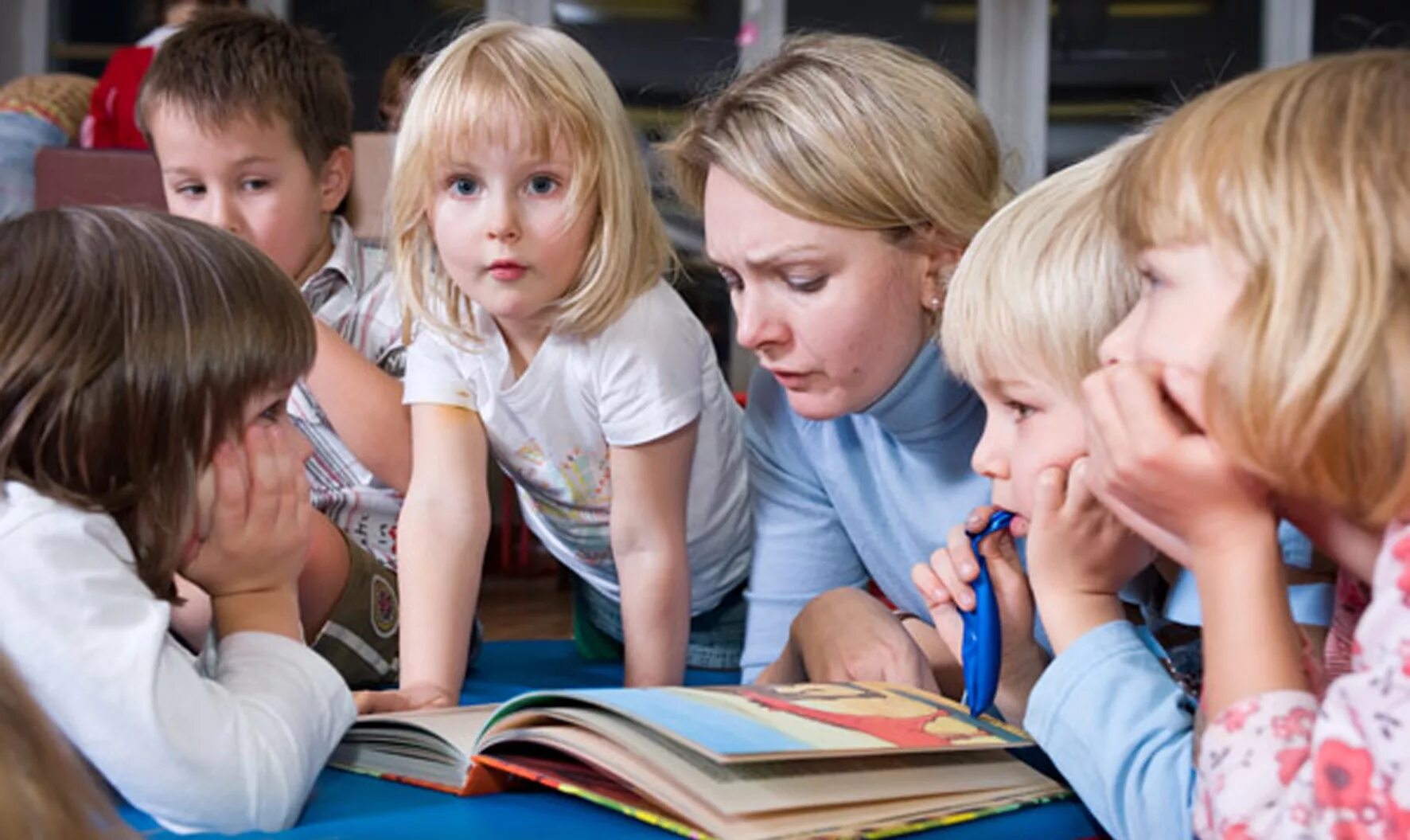Читающий воспитатель читающие дети. Воспитатель читает. Младшие дошкольники. Воспитатель читает сказку. Дети сидят вокруг учителя.