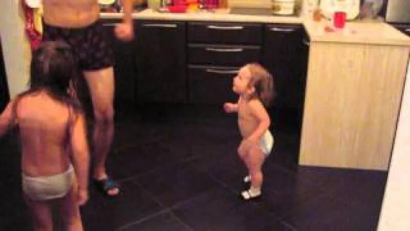 Дочка танцует. Папа танцует с дочкой. Отец танцует с дочкой на кухне. Дочка подсматривала за папой