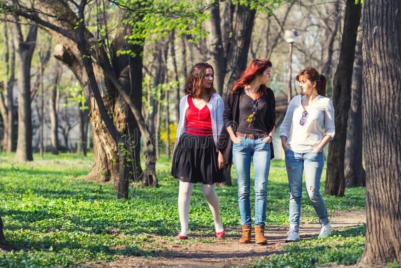 Гулять в настоящем времени. Три девушки в парке. Подруги гуляют. Девушка гуляет в парке. Прогулка подростков в парке.