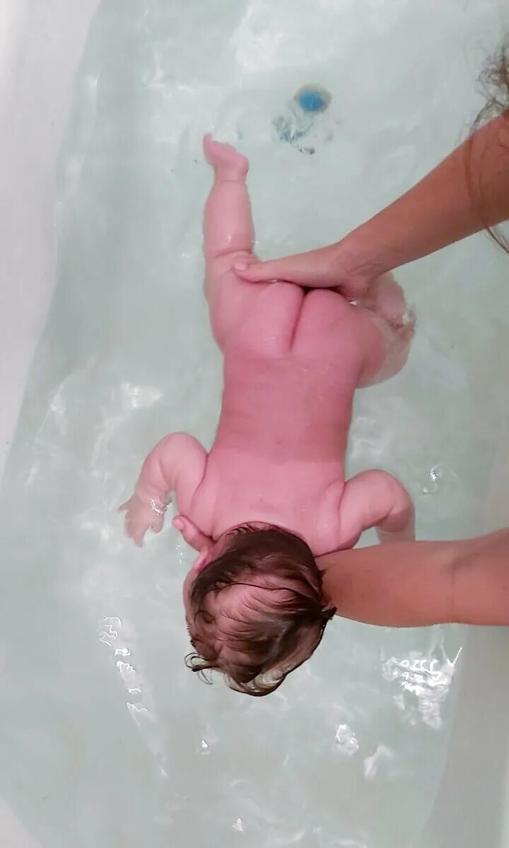 Младенец купается. Для купания малышей приспособления. Купание грудничка. Купание новорожденного в ванной. Купание в малой воде.