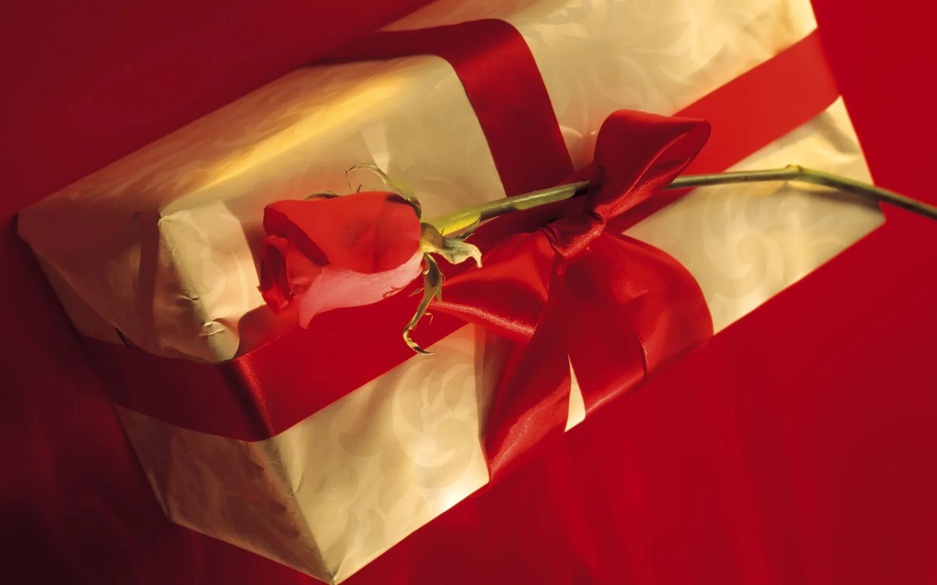 Подарочная коробка с красной лентой. Красная коробка с золотым бантом. Розы подарок. Упаковка подарка с красной лентой.