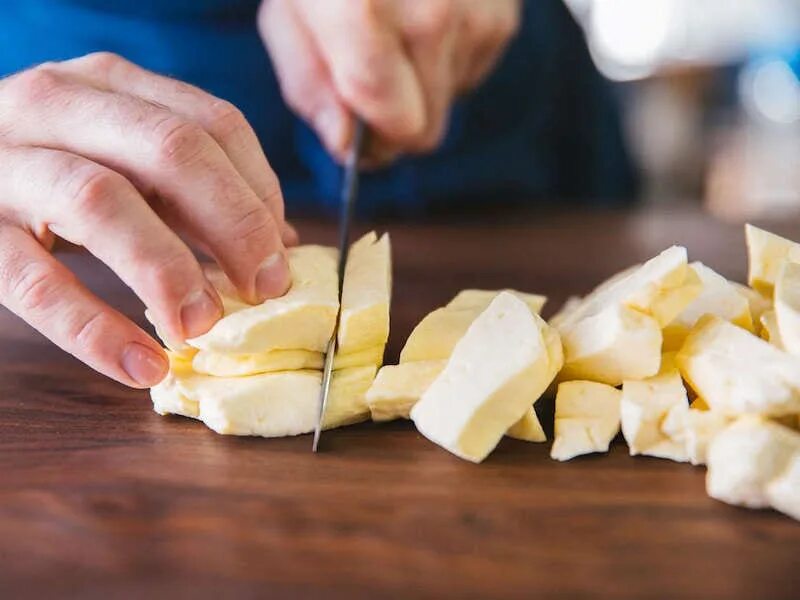 Вареный сыр. Порезать сыр небольшими кусочками. Сыр в бумаге. Сыр варка.