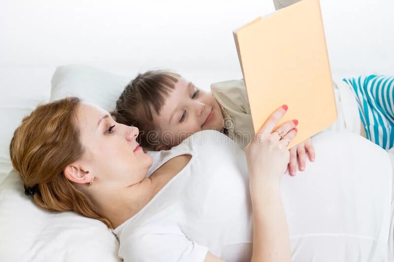 Мама читает сказку ребенку картинки. Старший ребёнок читает для беременной мамы. Мама читает книгу в кровати. Читать мама лизала
