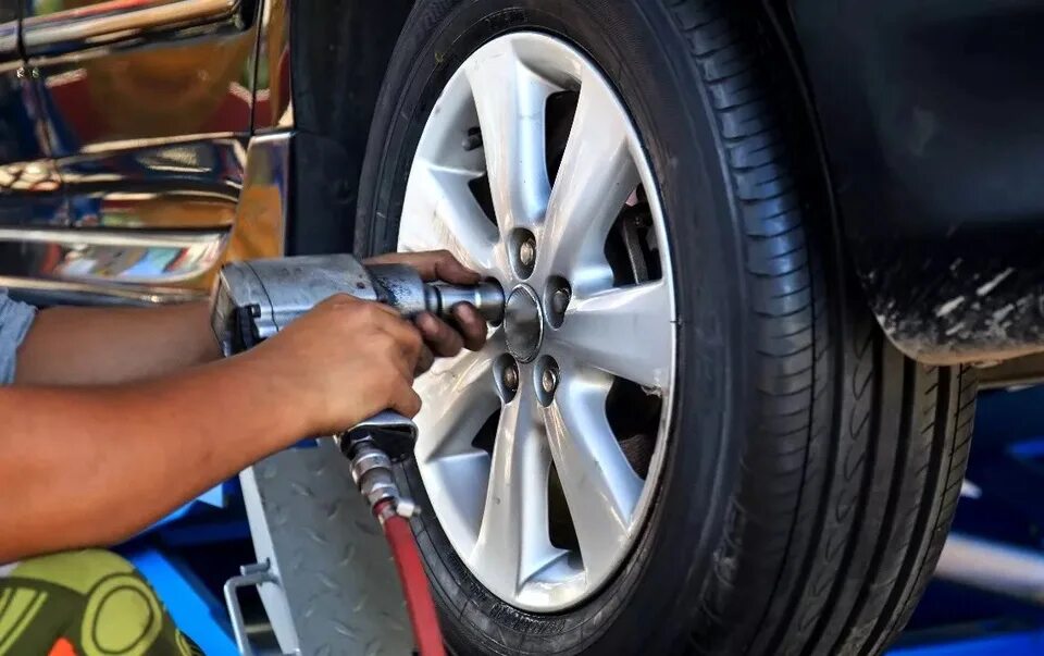 Установщик колес на автомобиля. Откручивать гайки на колесах. Монтаж колеса. Снять поставить. Постановка колес на автомобиле.
