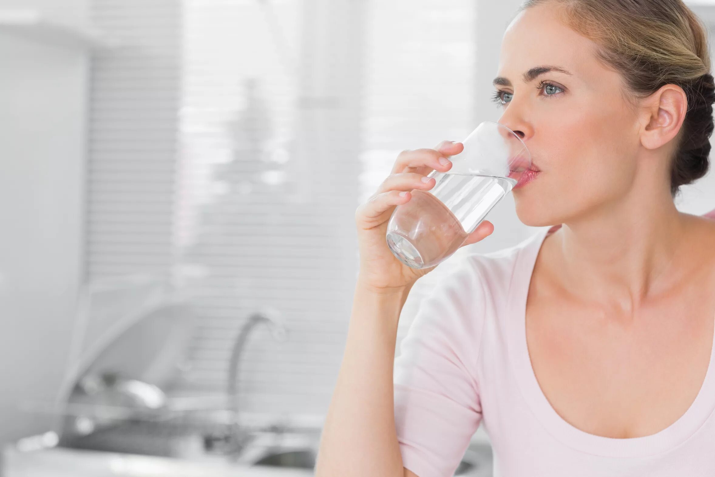 Запивать теплой водой. Женщина пьет воду. Женщина со стаканом воды. Девушка пьет из стакана. Питье воды.