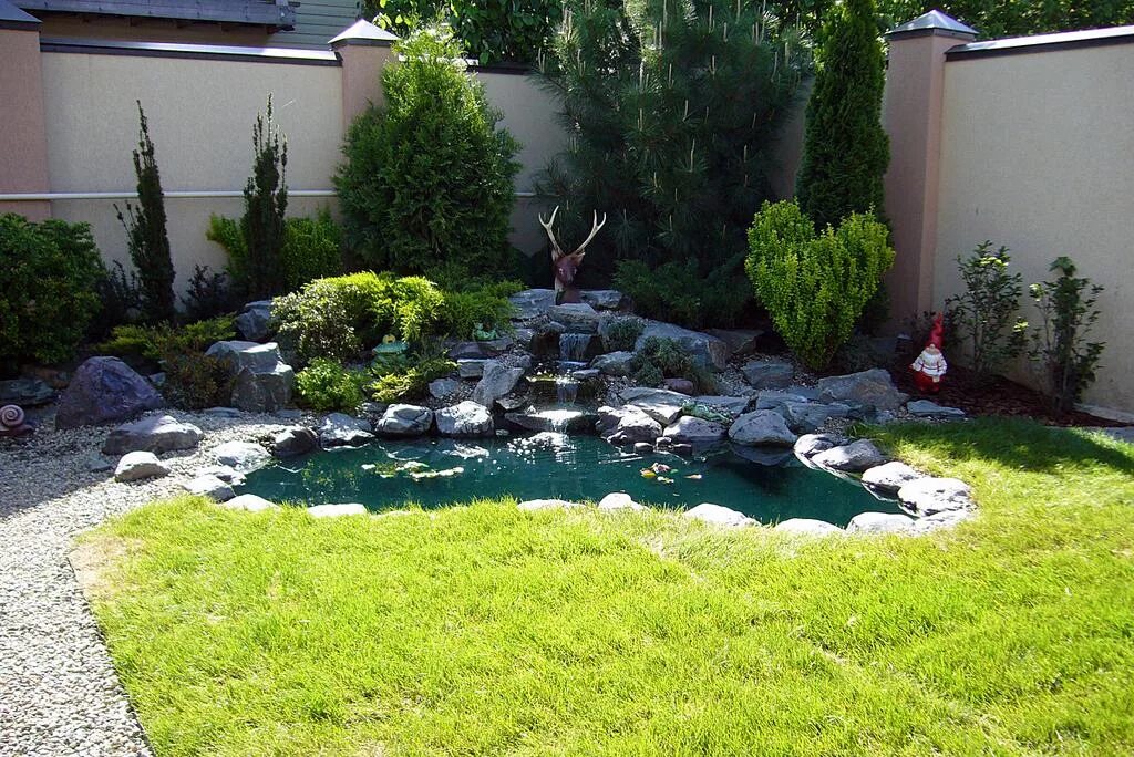 Искусственный водоем с альпийской горкой. Альпийские горки возле забора. Рокарий с прудом. Пруд в углу. Пруд в углу.