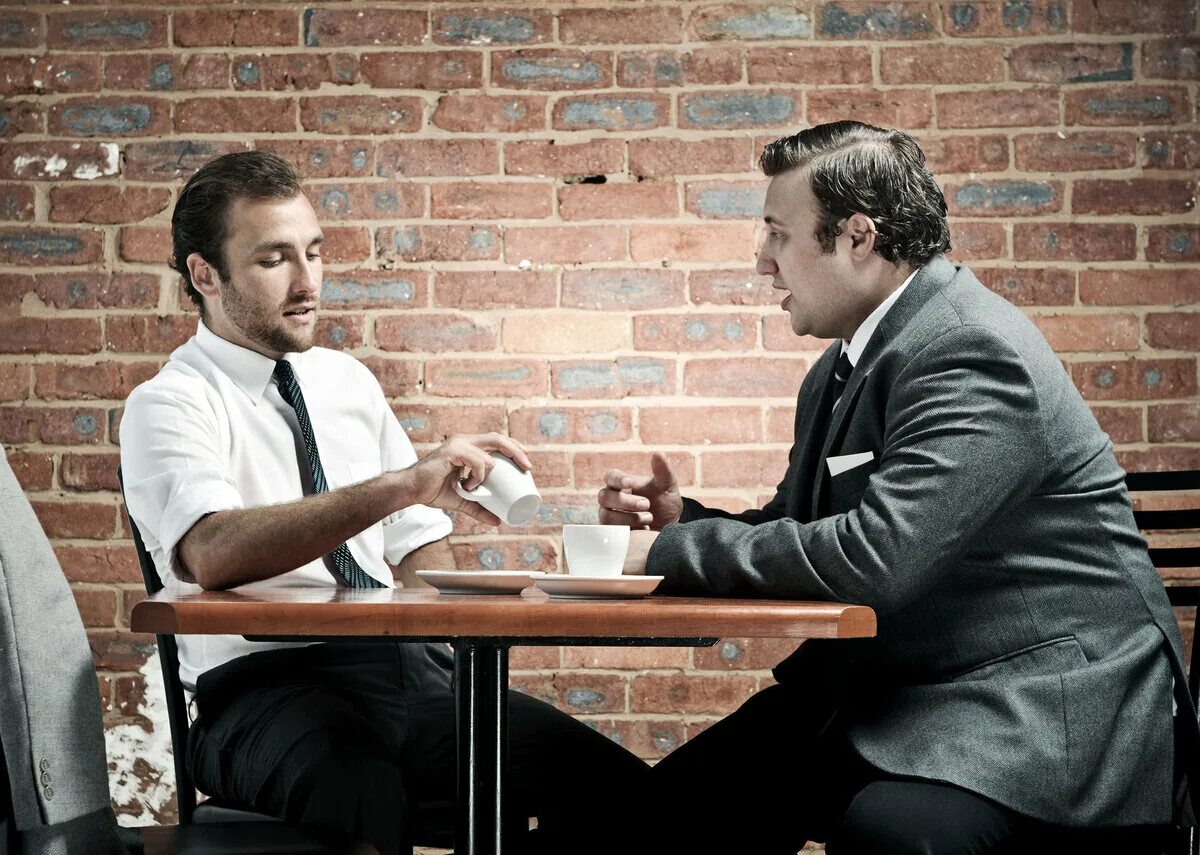 Слабые обсуждают. Два человека за столом. Разговор двух мужчин. Беседа двух мужчин. Два друга за столом.