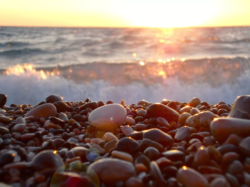 каменистый берег моря. море галька закат. камни на пляже. закат на море. камни море солнце.