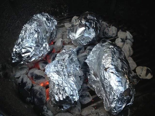 Сколько готовить картошку в углях. Картошка в фольге на углях. Картошка запеченная в фольге на углях. Печеная картошка в фольге на углях. Картошка в фольге на костре.