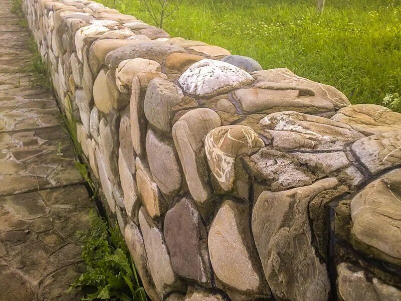 Фундамент из природного камня. Постелистый бутовый камень. забор из валунов. забор из природного камня. каменный забор.