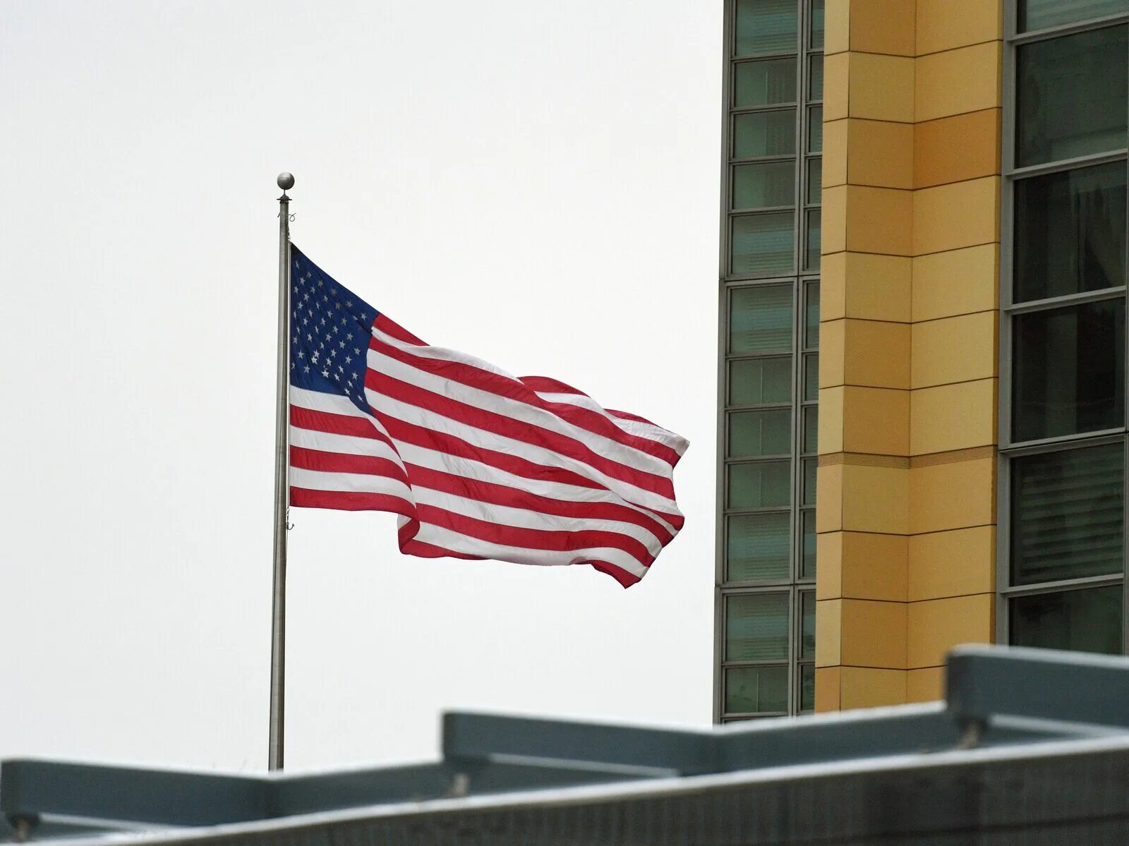 Сша расширил. Американский флаг на здании. Посольство США. Американские санкции. Посольство России в США.