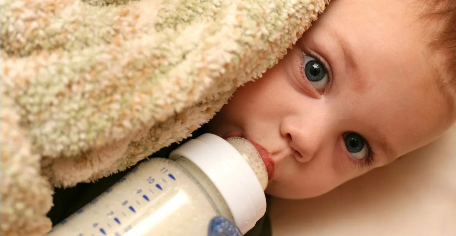 Малыш с бутылочкой. Искусственное вскармливание. Ребенок кушает из бутылочки. Малыш пьет из бутылочки.