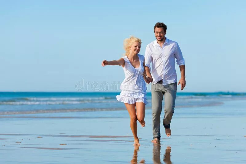 Влюбленная пара бегут по пляжу. Счастливая пара на пляже. Счастливая пара бежит по берегу моря. Счастливая пара средних лет. На море без жены