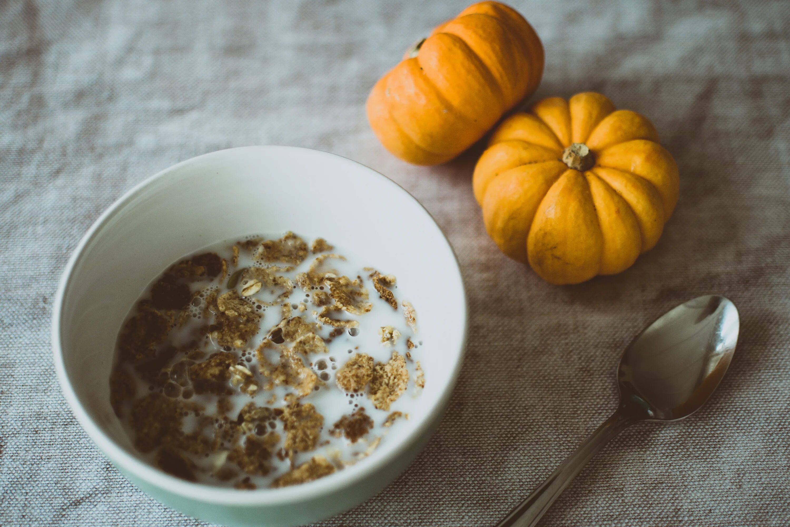Тыква овсяные хлопья. Тыква и рядом апельсин сверху. pumpkin porridge. картинка кухня стол где едят тыквенную кашу.