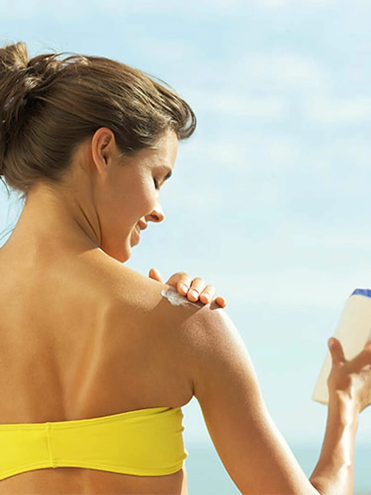 Нанесение крема на тело. Девушки мажутся кремом для загара. Солнцезащитный крем на спине. Кожа тела. Крем для тела.