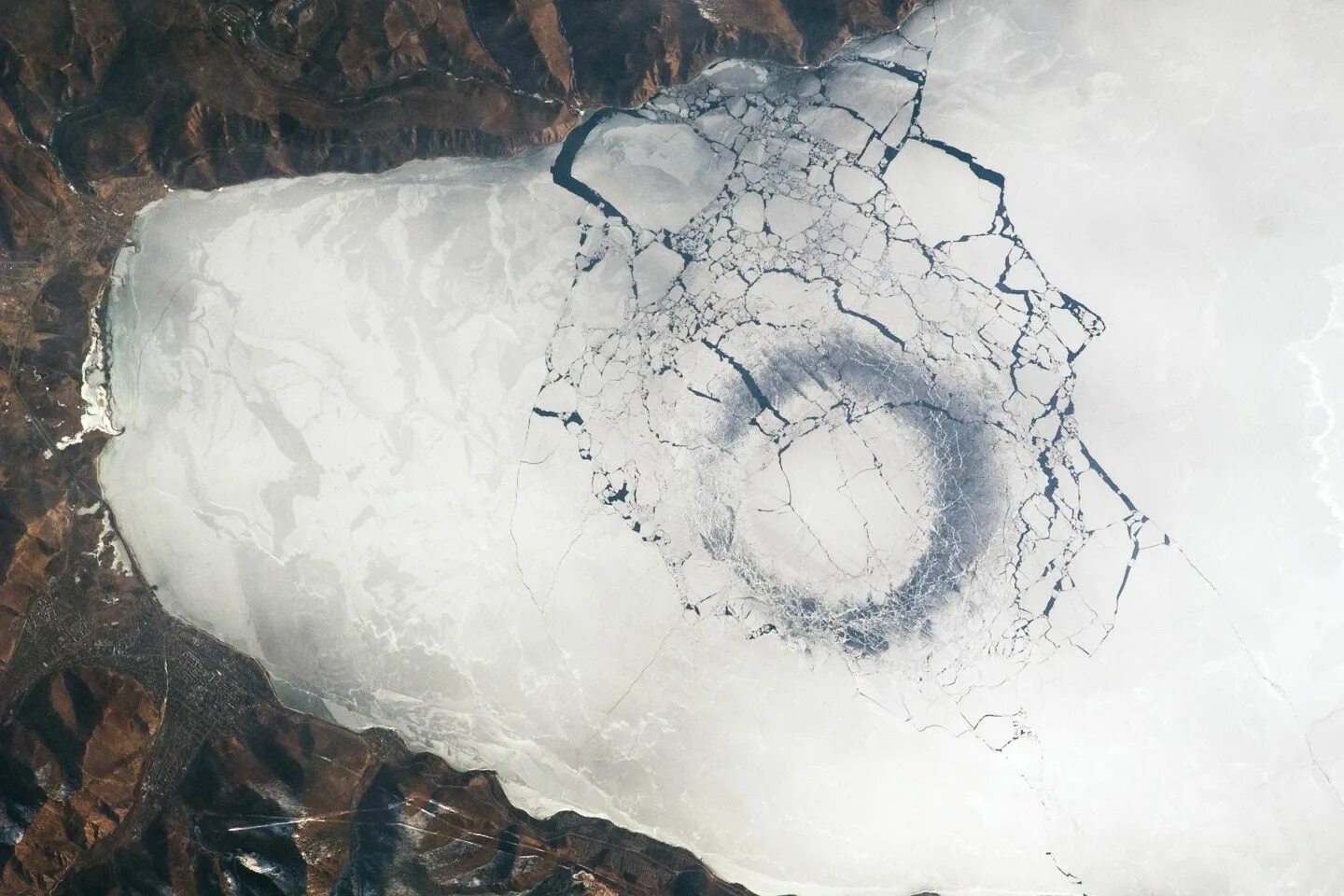 Трещины воды. Темные кольца на озере Байкал. Круги на льду Байкала. Кольца на льду Байкала. Озеро Байкал воронка.
