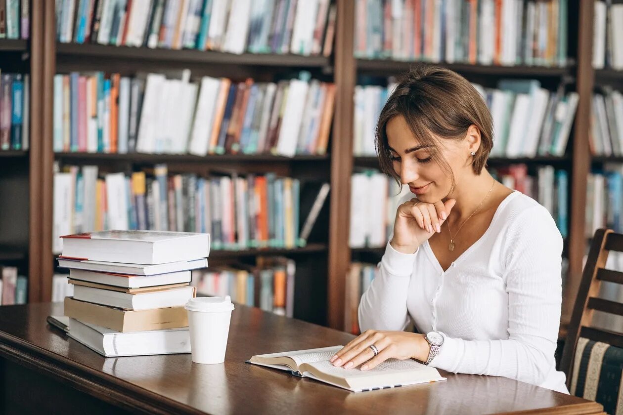 Девушка с учебником немецкого. Изучает книгу. Studying at the Library. Студентка собирает учебники.