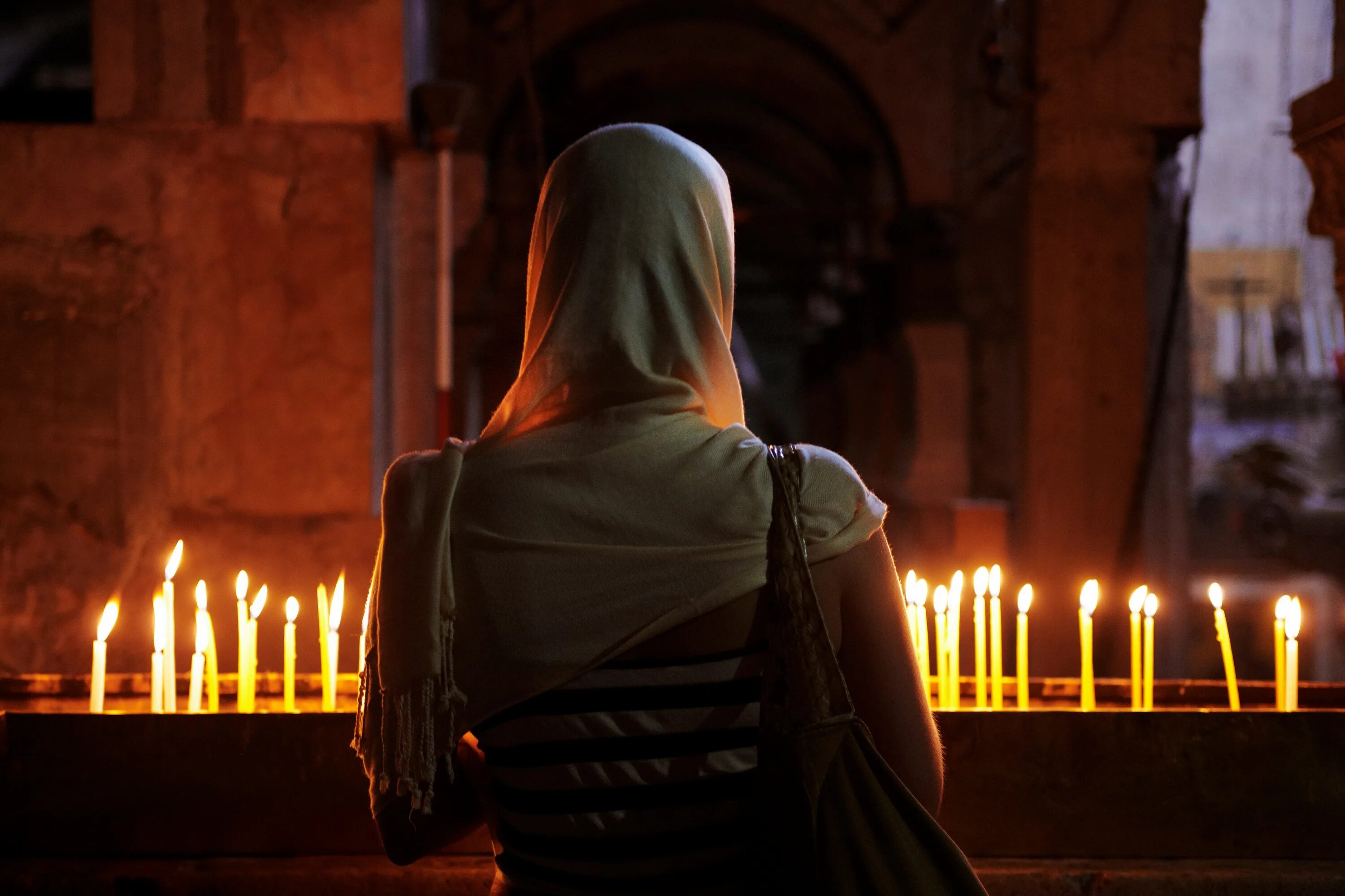 Мужчина ставит свечу. Женщина молится в храме. Молитва в церкви. Девушка в церкви со спины. Девушка в церкви со свечой.