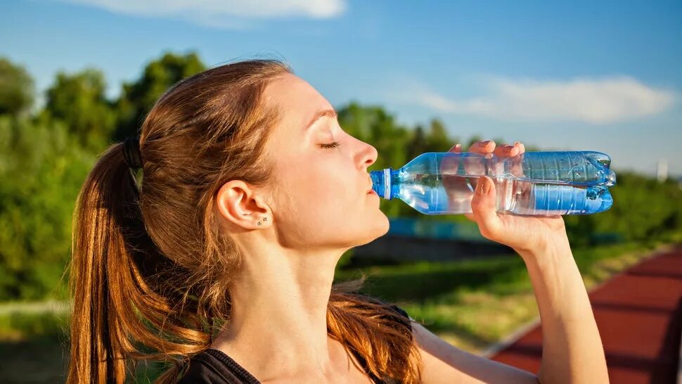 Пить. Пить воду. Употребление воды. Питьевая вода. Девушка с бутылкой воды.