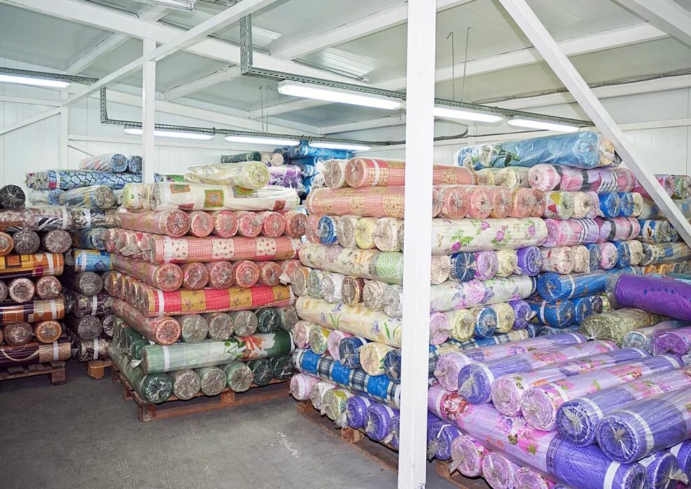 Рулоны ткани на складе. Оптовый склад тканей. Текстильные товары. Текстиль в рулонах.