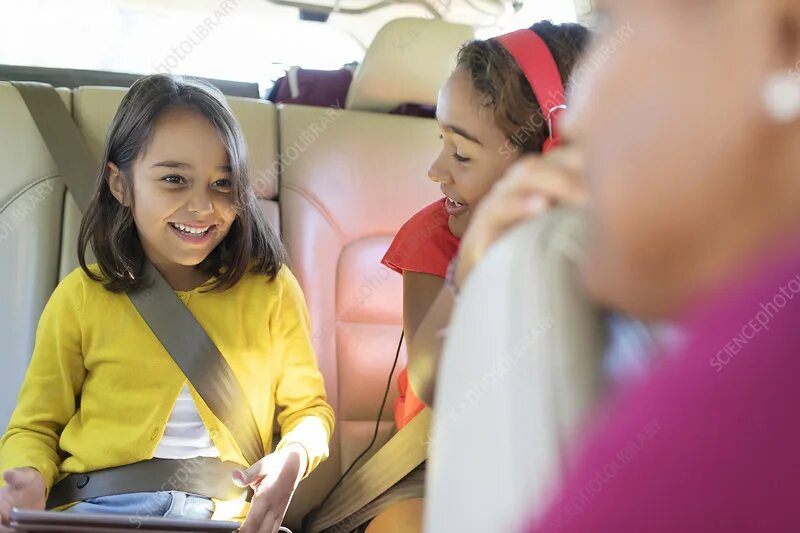 Children in the back Seat of the car. Child in the back of the car. Two children in the back of a car. Sister ride