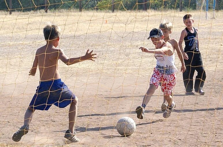 Игра в футбол во дворе. Футбол дети на улице. Футбол дети двор. Дети играют в футбол.