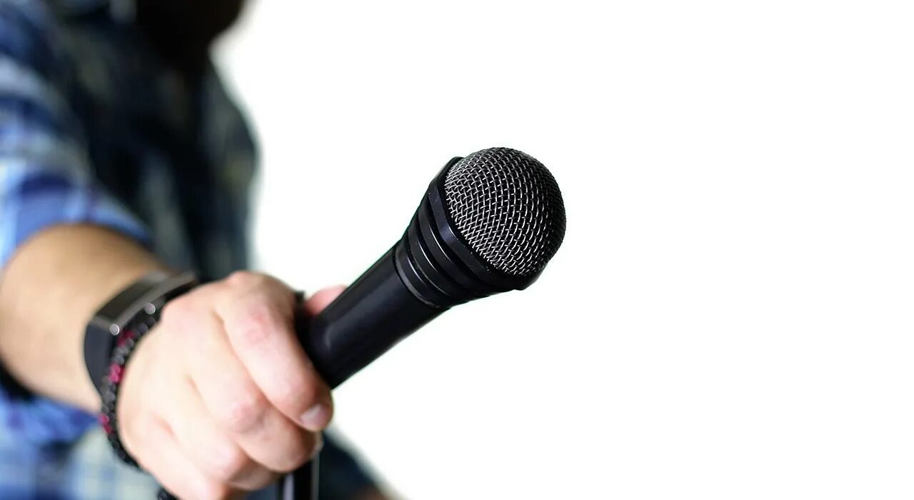 Игра микрофон говорить. Рука с микрофоном. Человек с микрофоном. Человек говорит в микрофон. Игровой микрофон в руках.