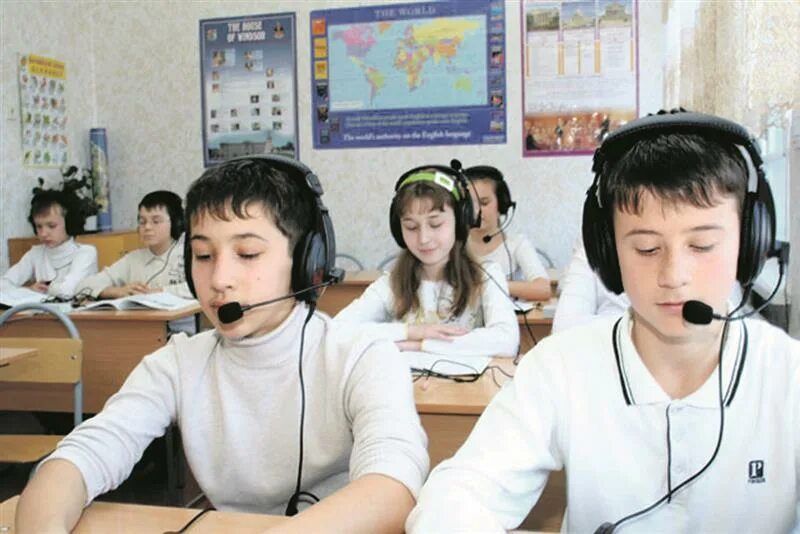 Студент в наушниках. Лингафонный кабинет в школе. Аудирование в школе. Групповые занятия с детьми. Школьник с наушниками.