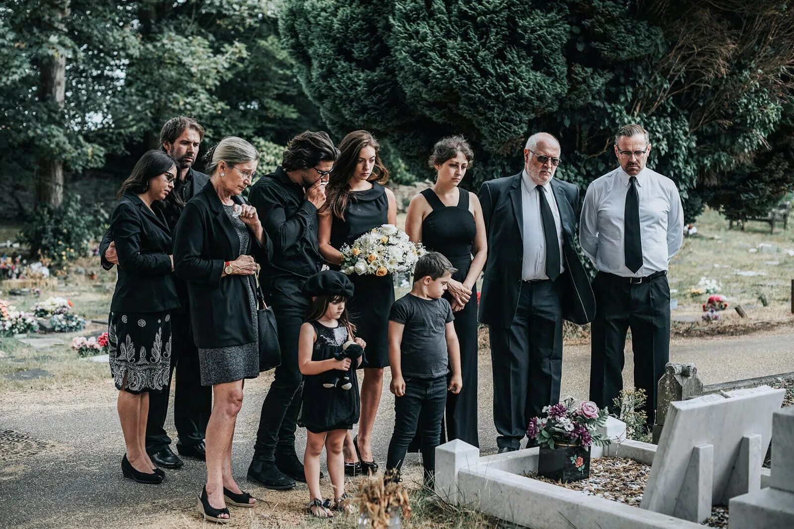 Похороны родственника. Семья на кладбище. Фото семей на кладбищах. Семья с детьми пришла на кладбище. Смеётся на похоронах женщина.